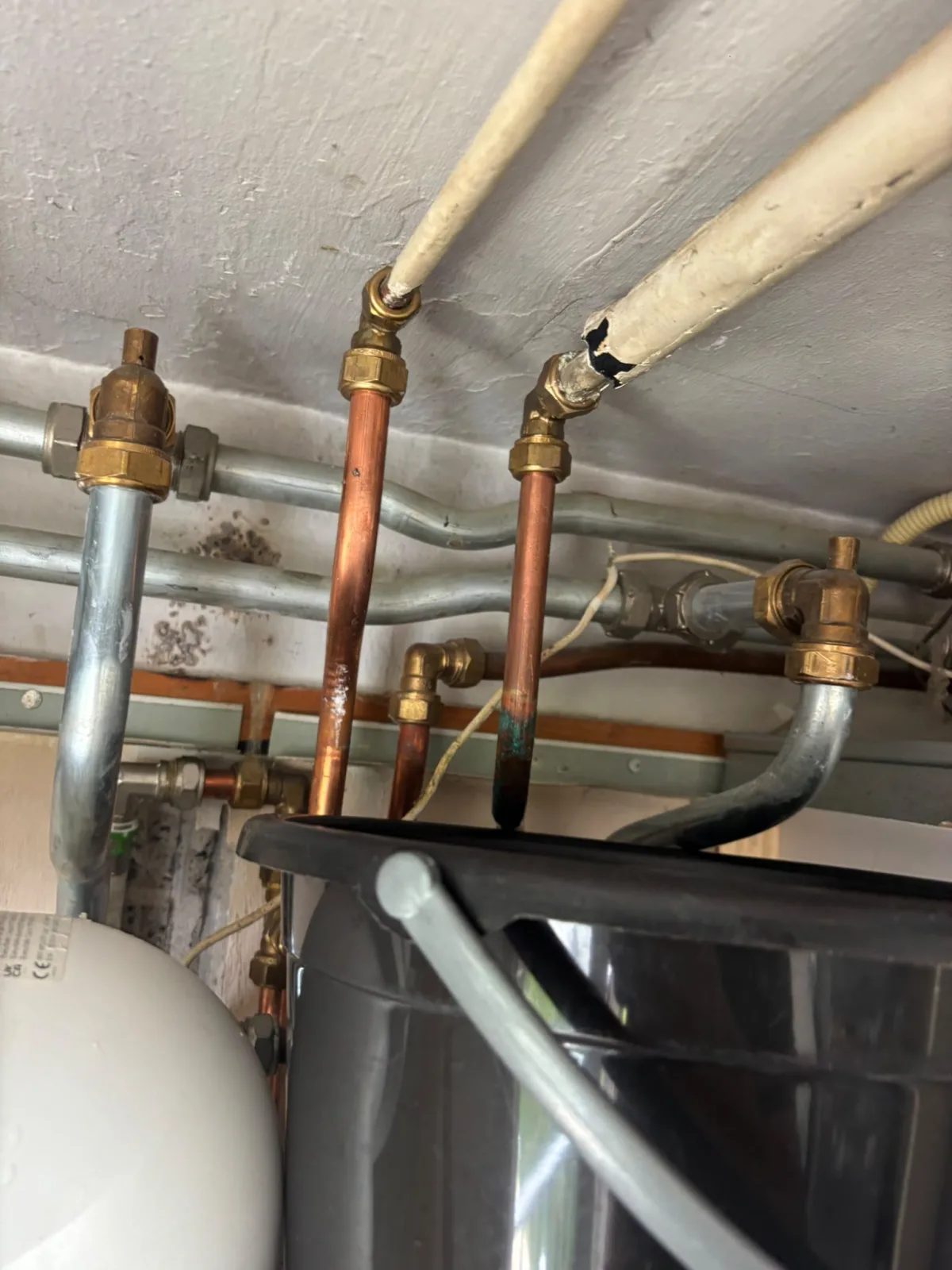 Lekkage bij CV-leidingen, waterschade, schimmel op muur en corrosie op koperen pijp.